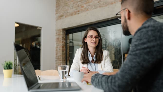A woman looks at an interviewer nervously