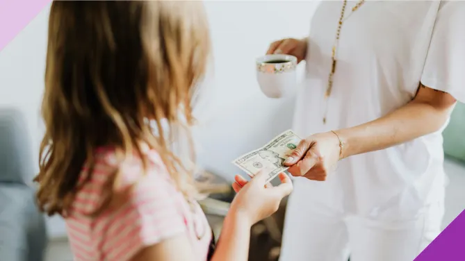A woman handing a 10 dollar bill to a little girl, illustrating the importance of teaching kids about money