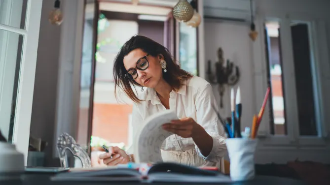 Woman flipping through papers in a creative field