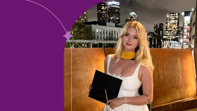 Cecelia D. in a white dress holding her graduation cap against the background of a city skyline. 
