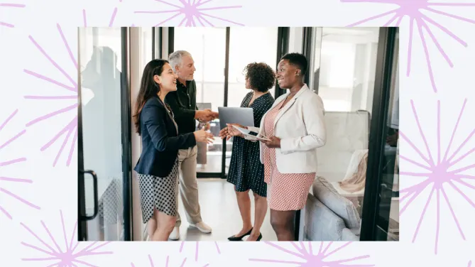 four people shaking hands in an office