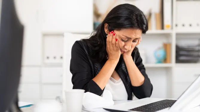 woman head in hands laptop