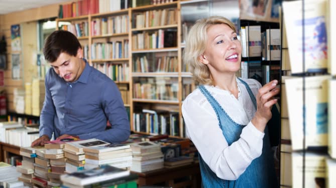 Librarian placing books on a shelf