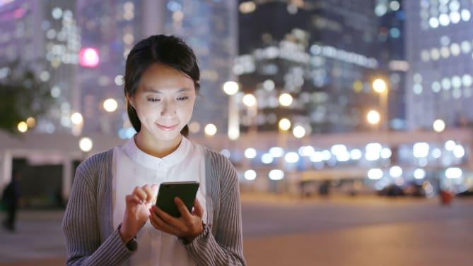 Woman looking at phone at night