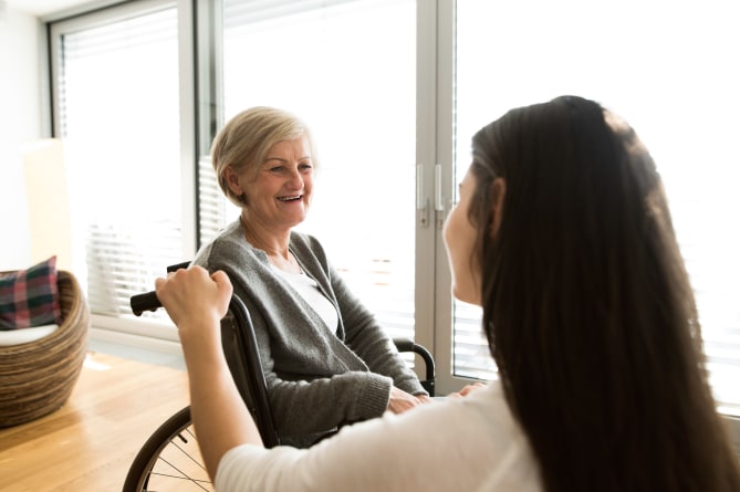 A woman caring for her older mother in a wheelchair