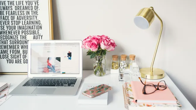 A laptop on a desk with a blog post on the screen.