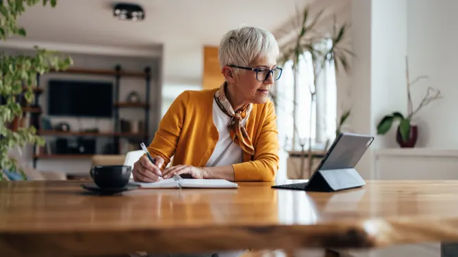 woman taking notes from computer