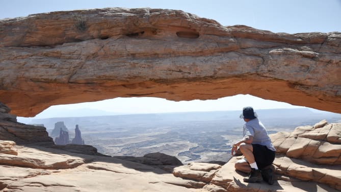 park ranger sitting on rocks under a branch