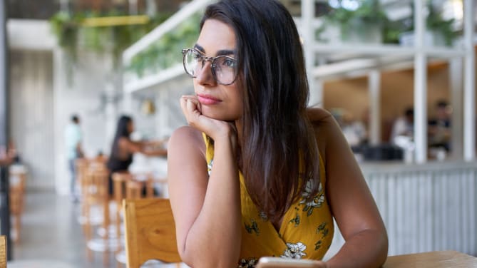 woman with hands on chin in cafe
