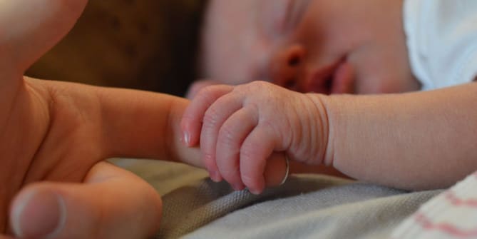 Baby holding finger