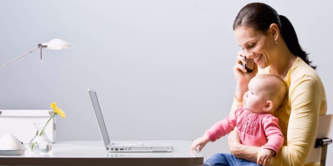 Woman holding baby at desk