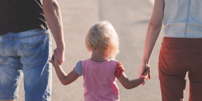 Child holding parents' hands