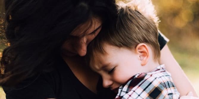Mother holding upset son
