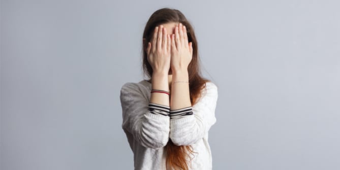 woman shielding face