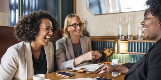 women laughing in a business meeting