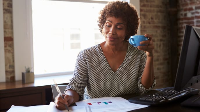 Woman working with cup of coffee