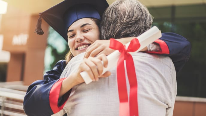 girl hugging her parent at a college graduation