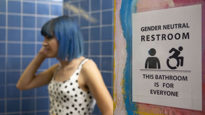 a non-binary femme in a gender neutral bathroom