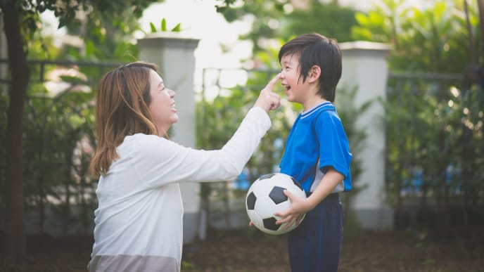 Woman with her son playing soccer