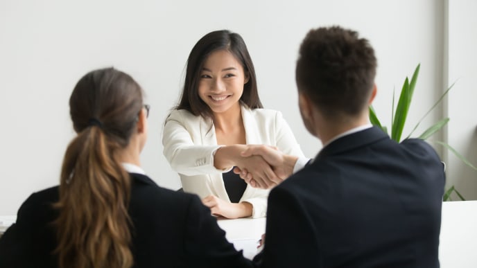 millennial shaking hands with job interviewers
