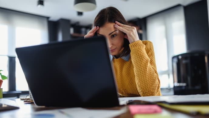 woman looking stressed in front of her laptop