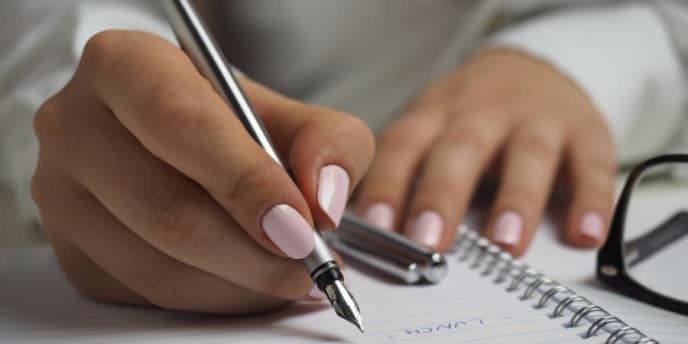 Woman writing to-do list to increase productivity
