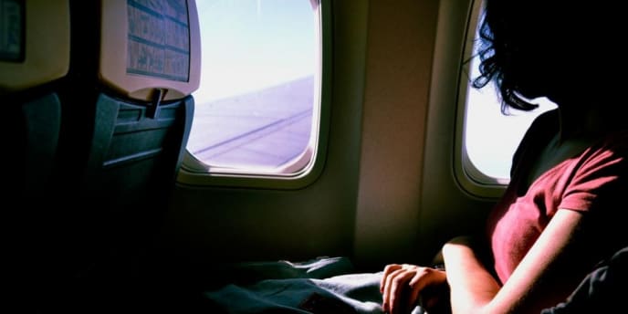 woman looking out of airplane window