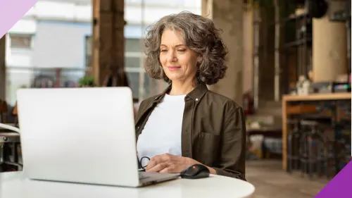 An older women working at an office to illustrate that it's possible to overcome ageism in your job search