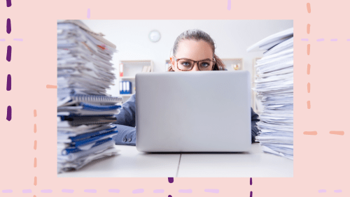 a woman on a laptop surrounded by paperwork.