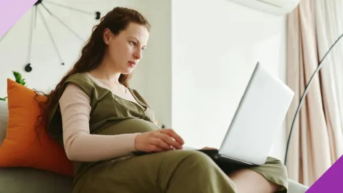 A pregnant woman working in her laptop to illustrate the importance of learning if you can get fired for being pregnant