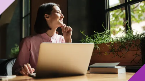 A woman at her work desk smiles while she looks at the window, illustrating you can grow your career once you unlearn certain behaviors
