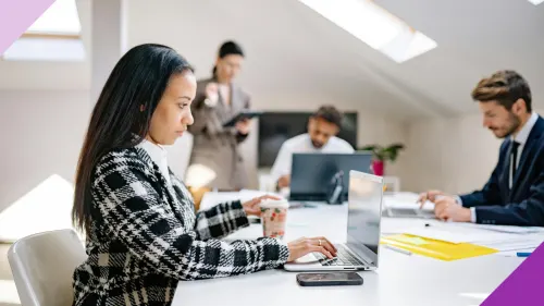 Women typing in her laptop at an office to illustrate the importance of learning how to embrace AI in the workplace