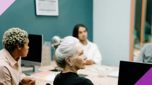 Three women at an office, one of them is a senior to illustrate the importance of discussing AI and ageism in the workplace