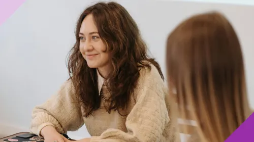 A woman smiling at an office to illustrate the importance of learning if “fake it until you make it” is a good career advice for you