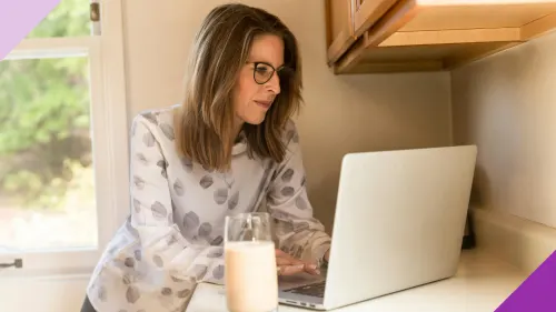 A woman at home typing on a laptop to illustrate the importance of learning what to do with your 401(k) after a layoff