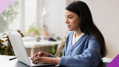 A woman at her work desk typing on a laptop to illustrate the importance of learning how to document everything at work smartly