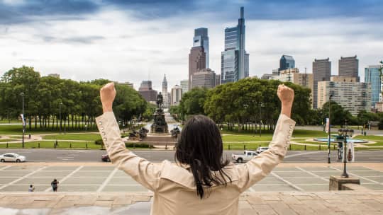 woman doing the Rocky pose on the Rocky steps