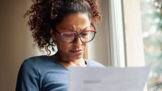 Stressed woman looking at paper