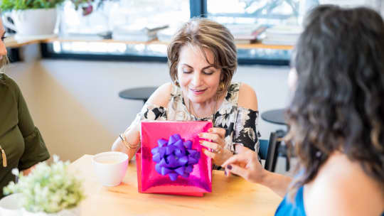 mother receiving and opening pink gift