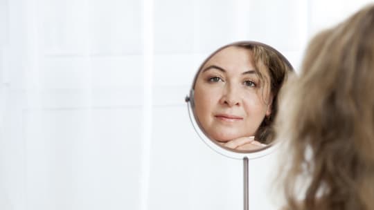 Woman looks in mirror