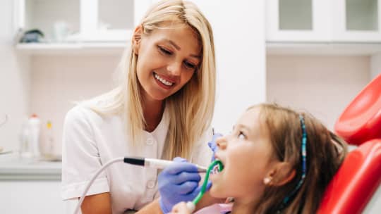 dental hygienist examining patient