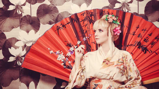 young white woman in kimono with sakura and decoration