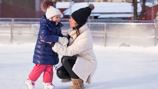 Woman and daughter ice skating