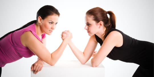 Businesswomen arm wrestling