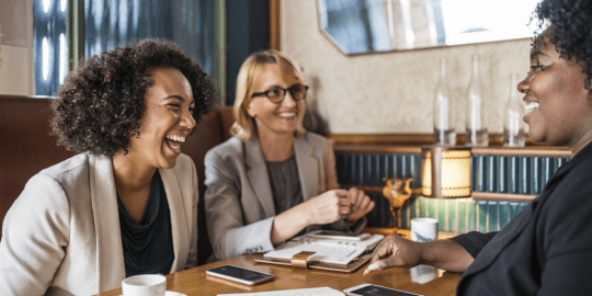 women laughing in a business meeting