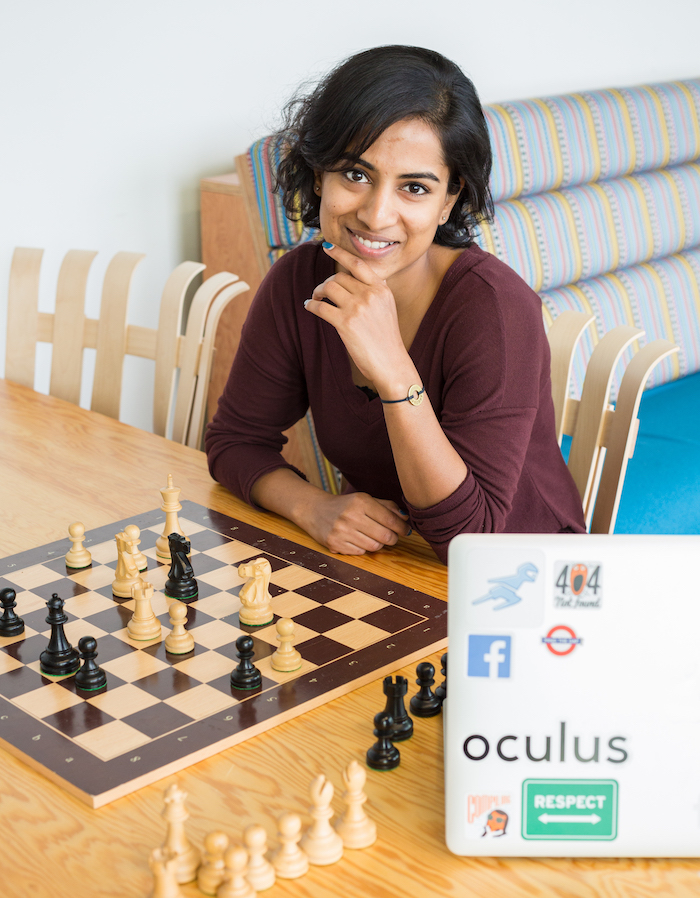 Nishita smiling while seated in front of a chess board.