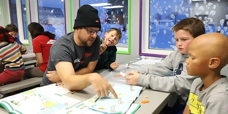 Dow employee mentor helps FIRST LEGO League Explore students build a LEGO wind turbine at the Fort Saskatchewan Boys and Girls Club in Alberta, Canada.